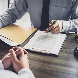 a person discussing a document to someone across him